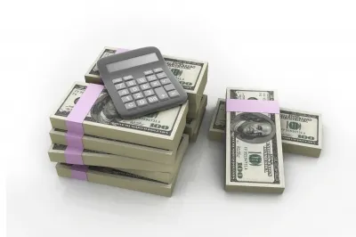 A pile of money with a calculator on top